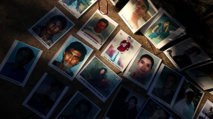 Photographs of people who disappeared while attempting to migrate to the United States are laid out across the street from the US Capitol in Washington, DC, October 19, 2021. 